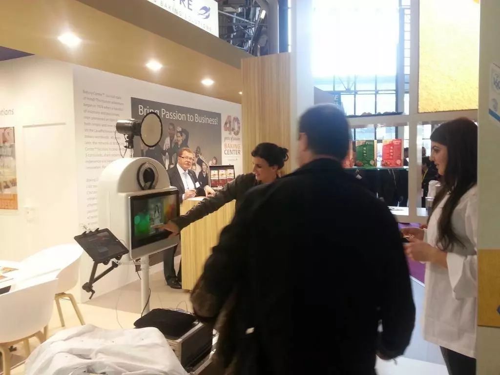 Visiteurs devant la borne photo sur un stand de salon fêtant ses 40 ans