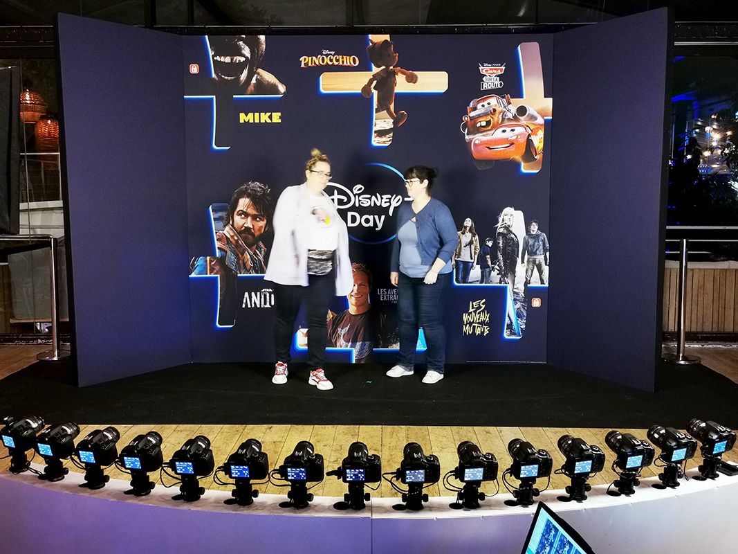 Deux invitées sur le plateau Disney Day, affiches Pinocchio et Cars, rangée d'appareils photo