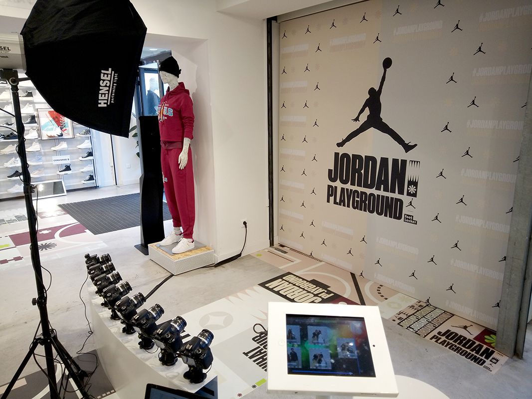 Plateau Bullet Time devant le mur Jordan Playground, mannequin en survêtement rouge et tablette de partage