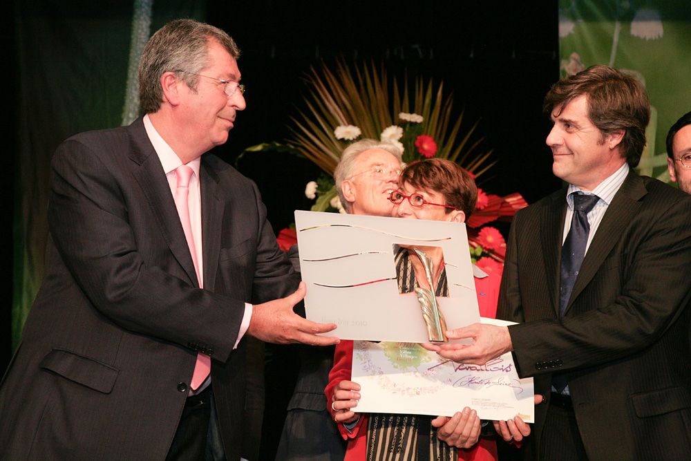 Élus recevant un diplôme sur scène lors de la remise des prix Villes et Villages Fleuris