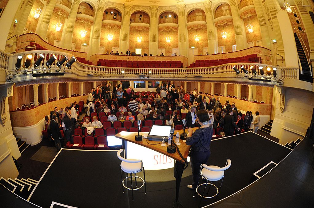 Théâtre à l'italienne vu depuis la scène au fisheye, balcons dorés et public installé