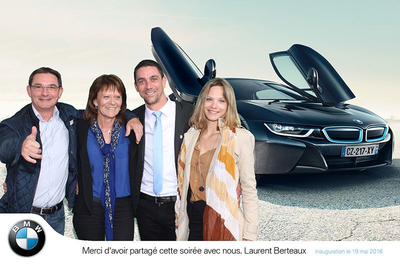Quatre invités levant le pouce devant une BMW i8 aux portes ouvertes, tirage avec logo BMW