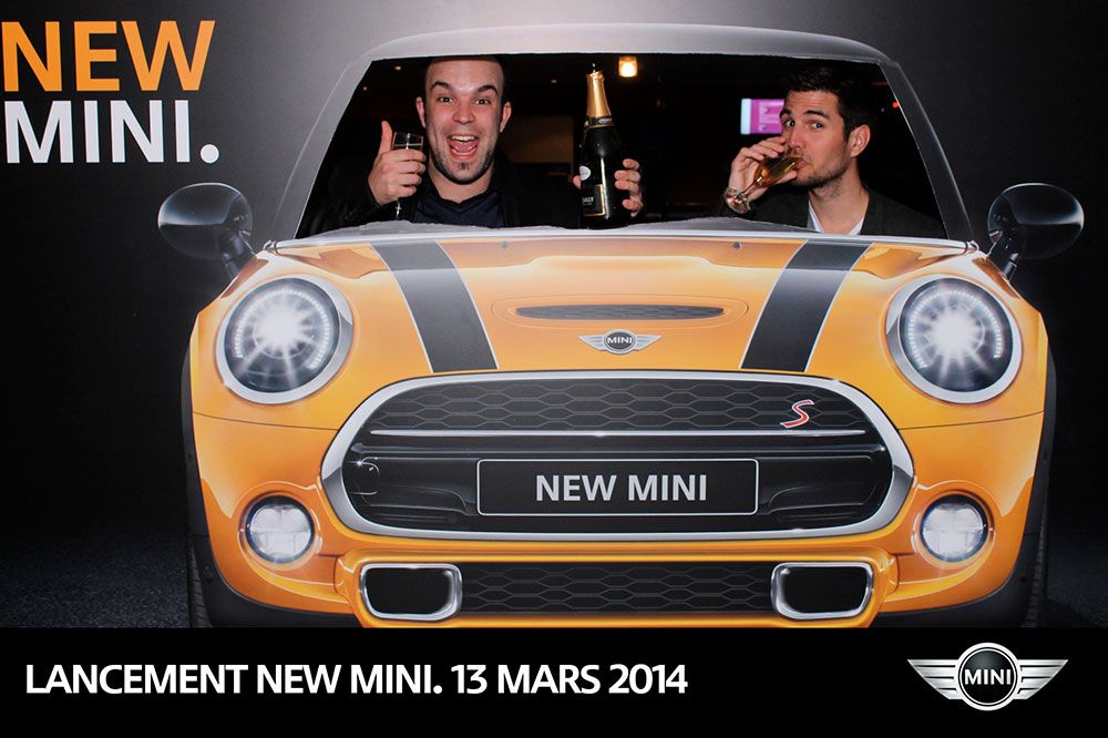 Deux invités au volant de la nouvelle MINI grâce au panneau silhouette, coupe de champagne en main