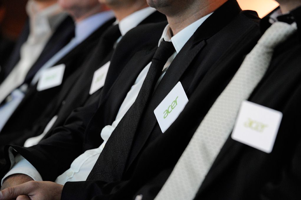 Équipe en costumes noirs portant des badges Acer, vue rapprochée