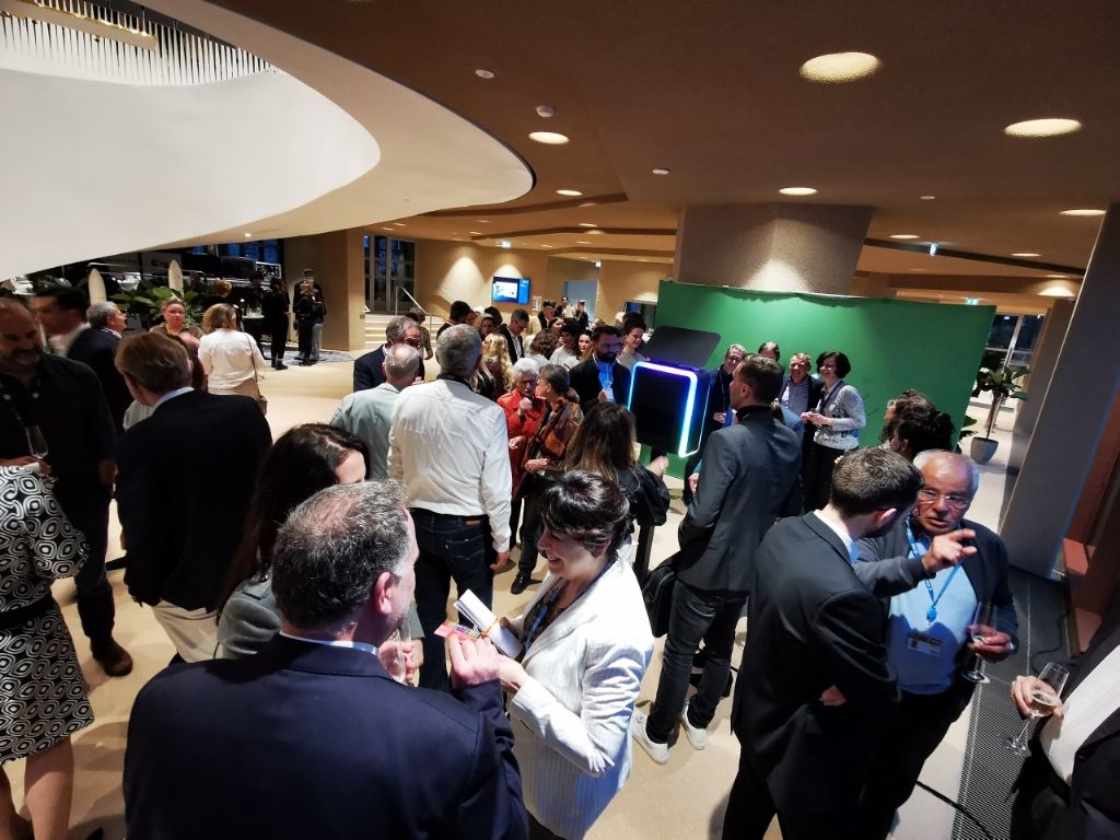 Foule d'invités dans le hall, borne photo visible au fond