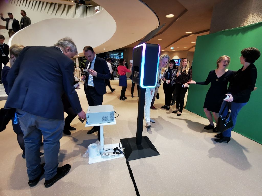 Invité consultant l'écran de la borne photo devant le fond vert