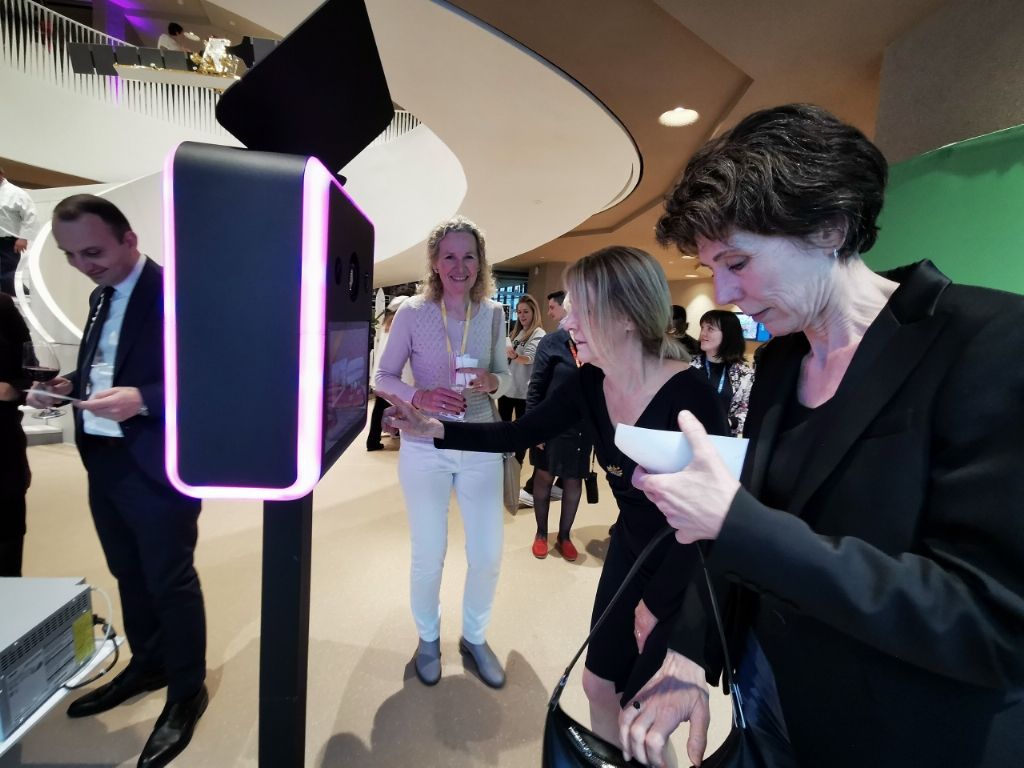 Invitée récupérant sa photo à la borne aux contours lumineux roses