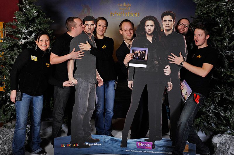 Groupe d'invités entourant les silhouettes Twilight dans un décor de sapins