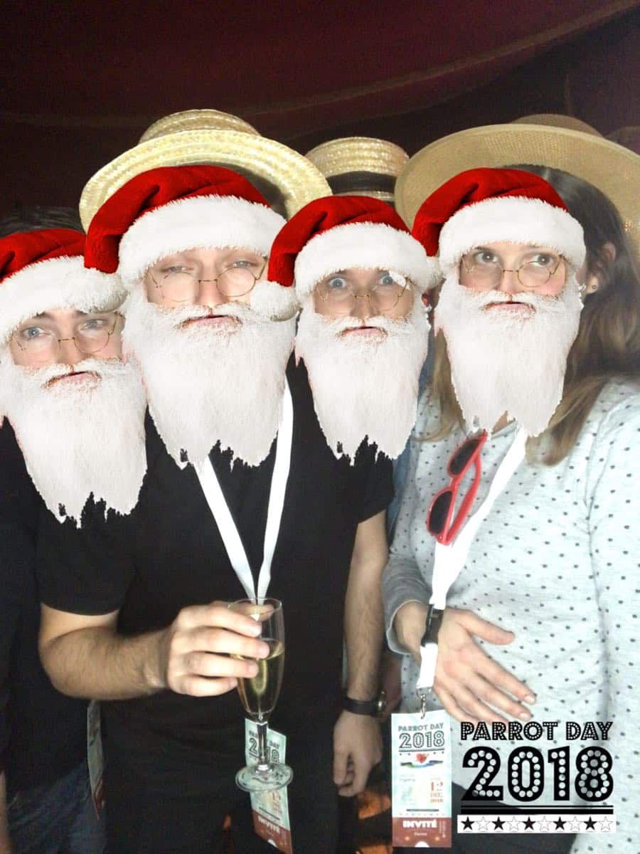 Quatre collègues affublés de barbes et bonnets de père Noël par un filtre animé, cadre Parrot Day 2018