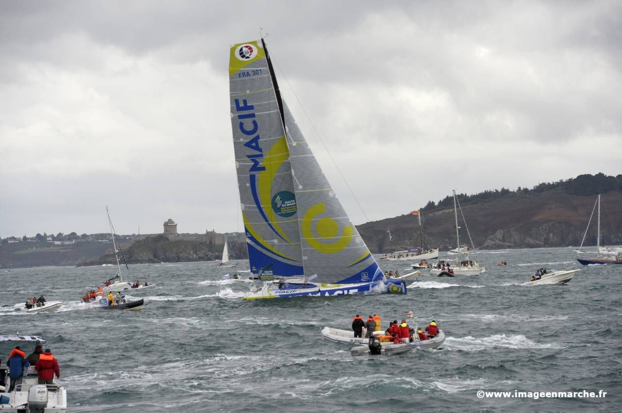 Monocoque Macif voiles jaunes et bleues, escorté de semi-rigides