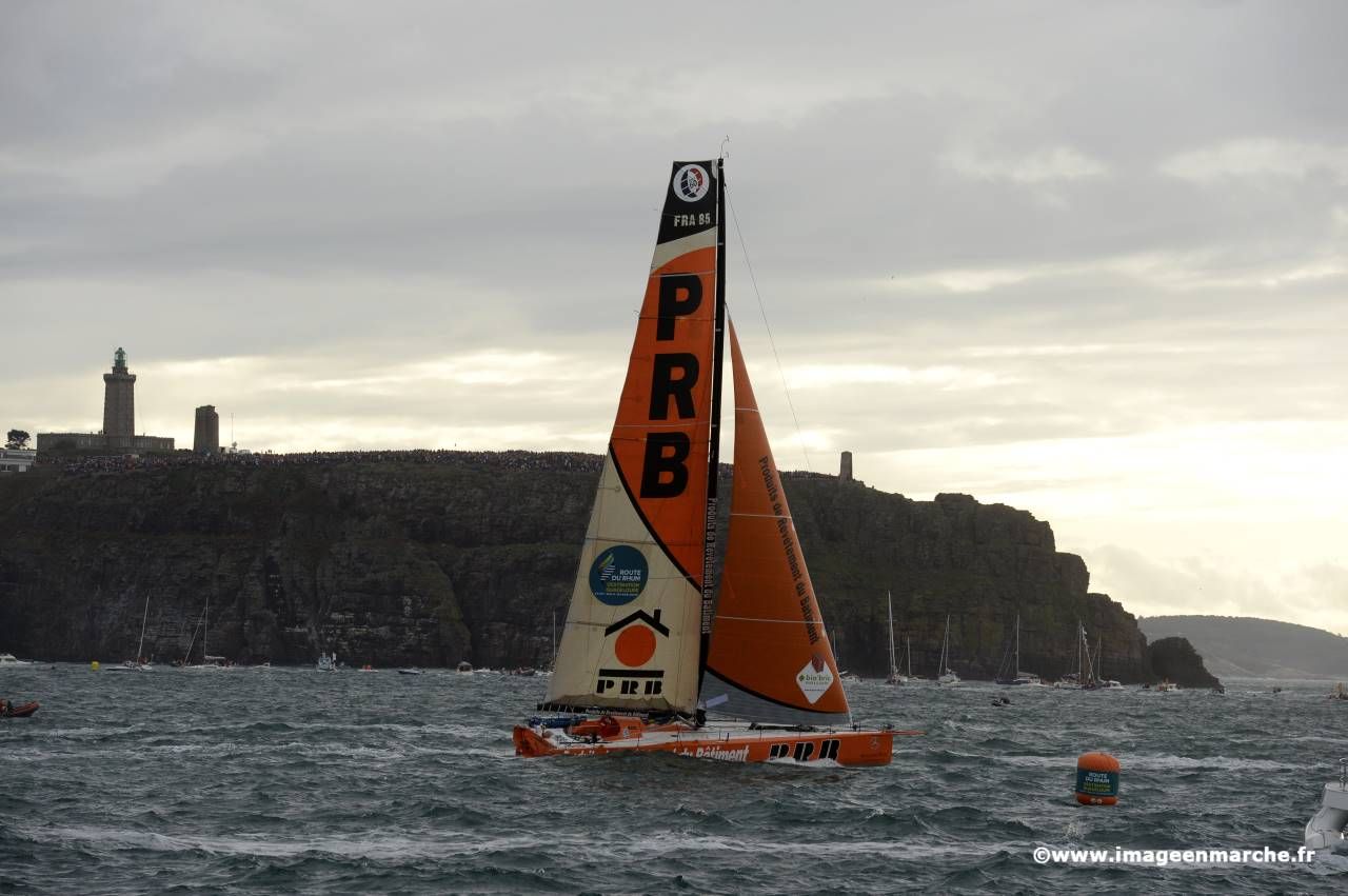 Monocoque PRB orange devant les falaises et le phare de la pointe