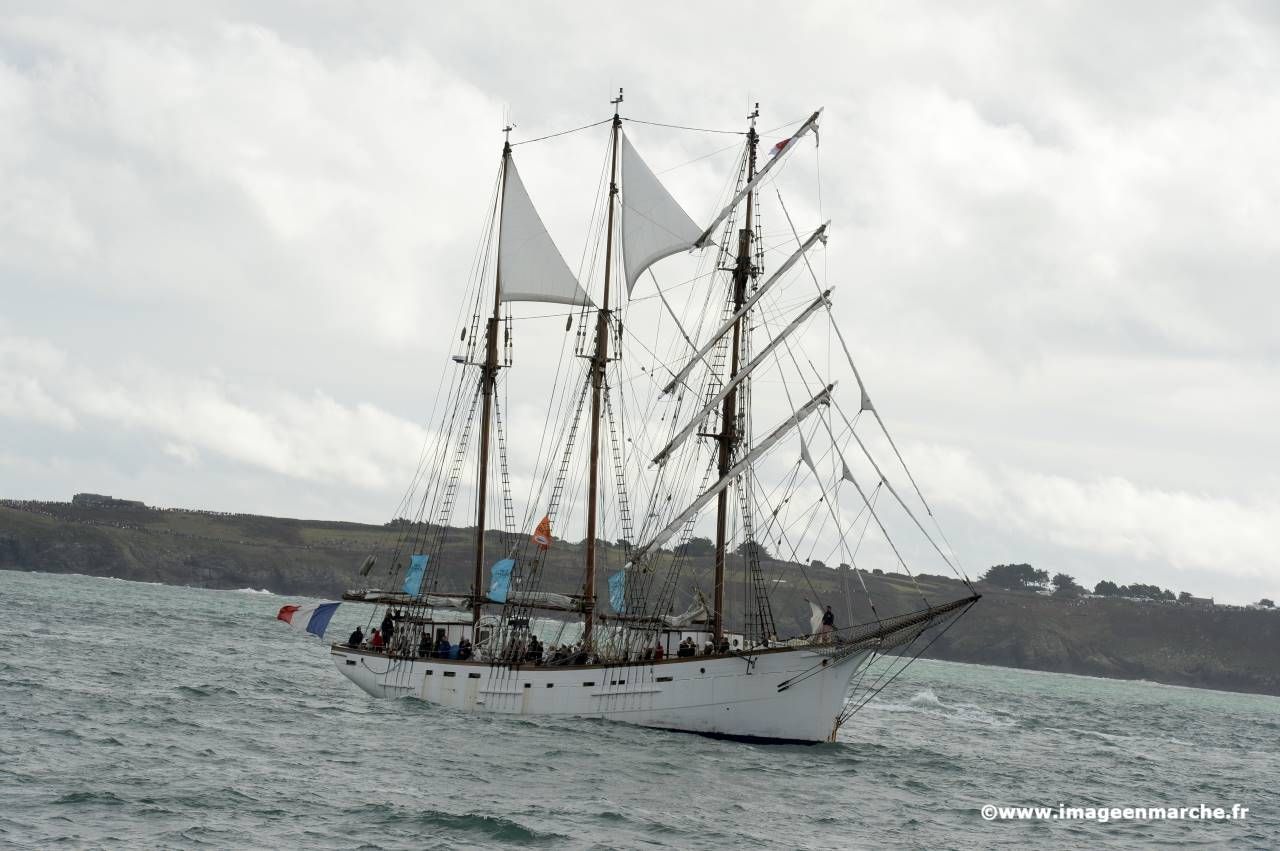 Trois-mâts sous voiles longeant la côte