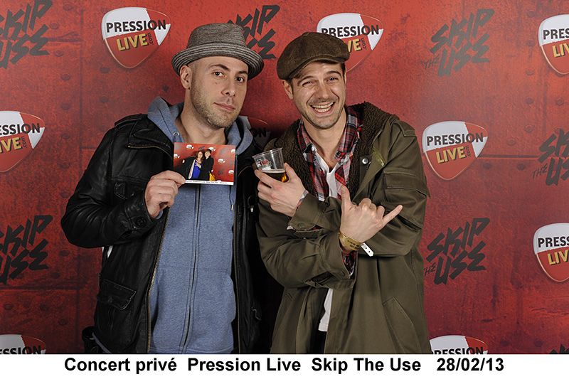 Deux invités posant devant le photocall Pression Live