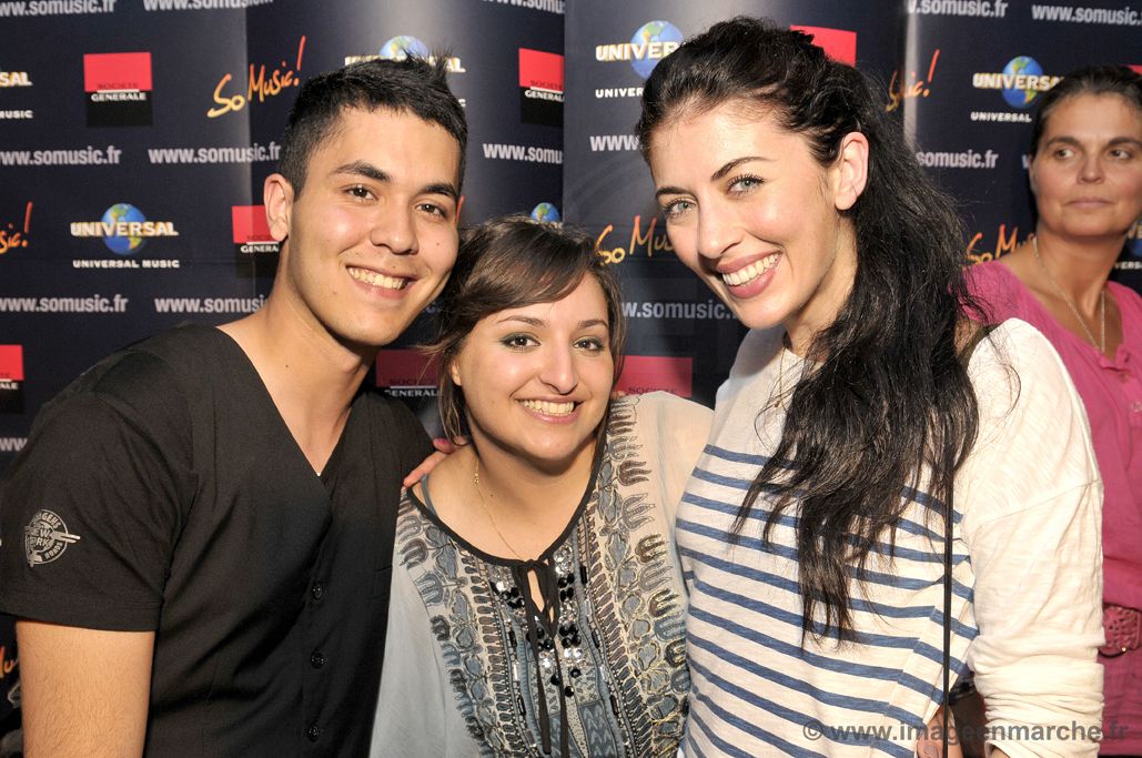 Trois invités souriants devant le photocall So Music et Universal